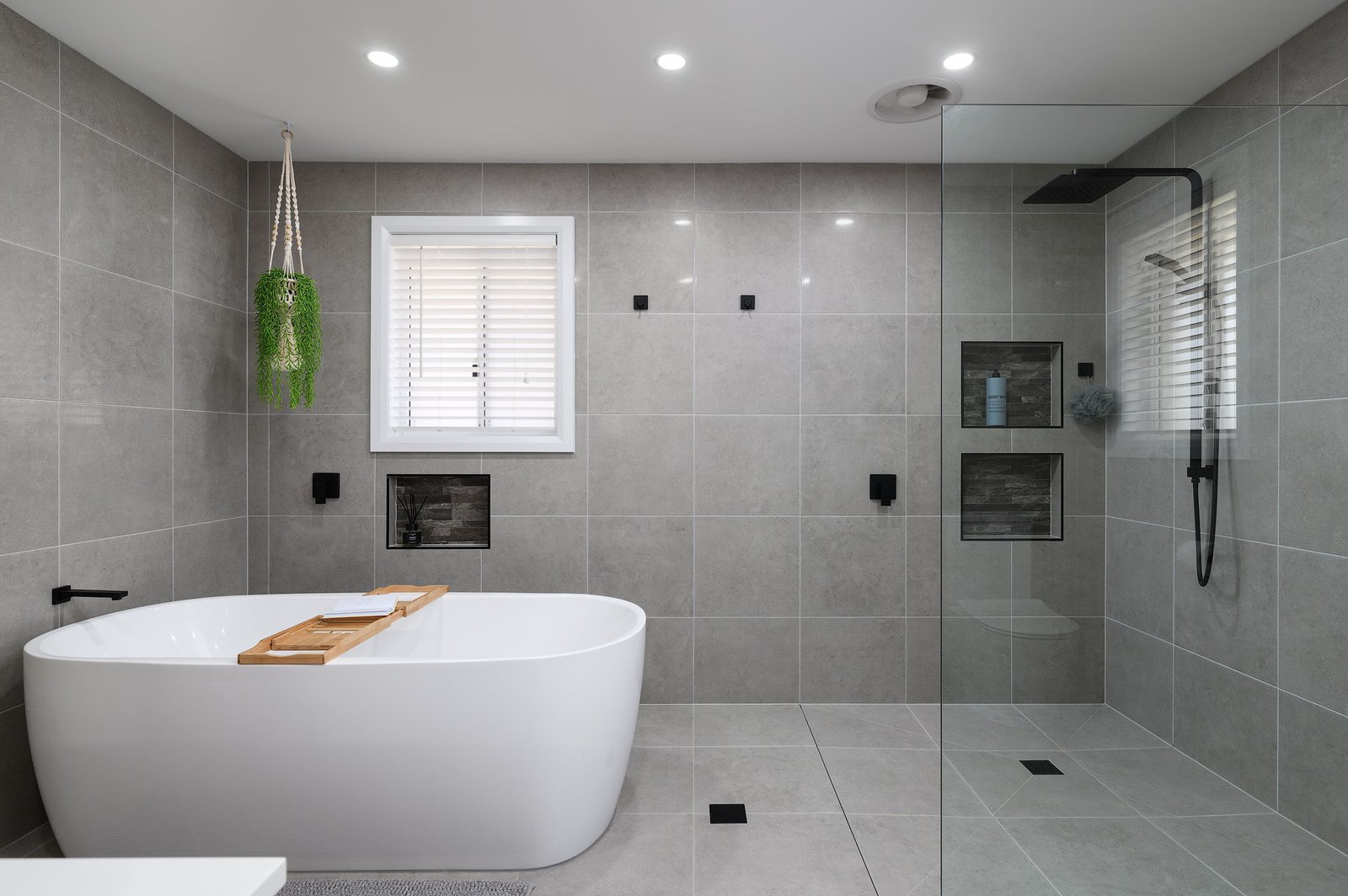 Sleek freestanding tub, this modern bathroom is designed for ultimate relaxation. The space includes stylish grey tiles and chic black fixtures