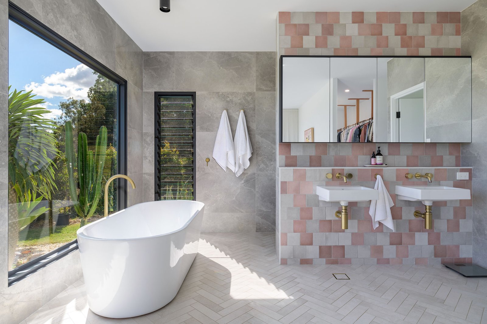 sophisticated en suite designed by Zerner Building Company, the freestanding tub is paired with brass and gold fixtures. The tub’s placement offers an amazing view of the property’s gardens and expansive acreage