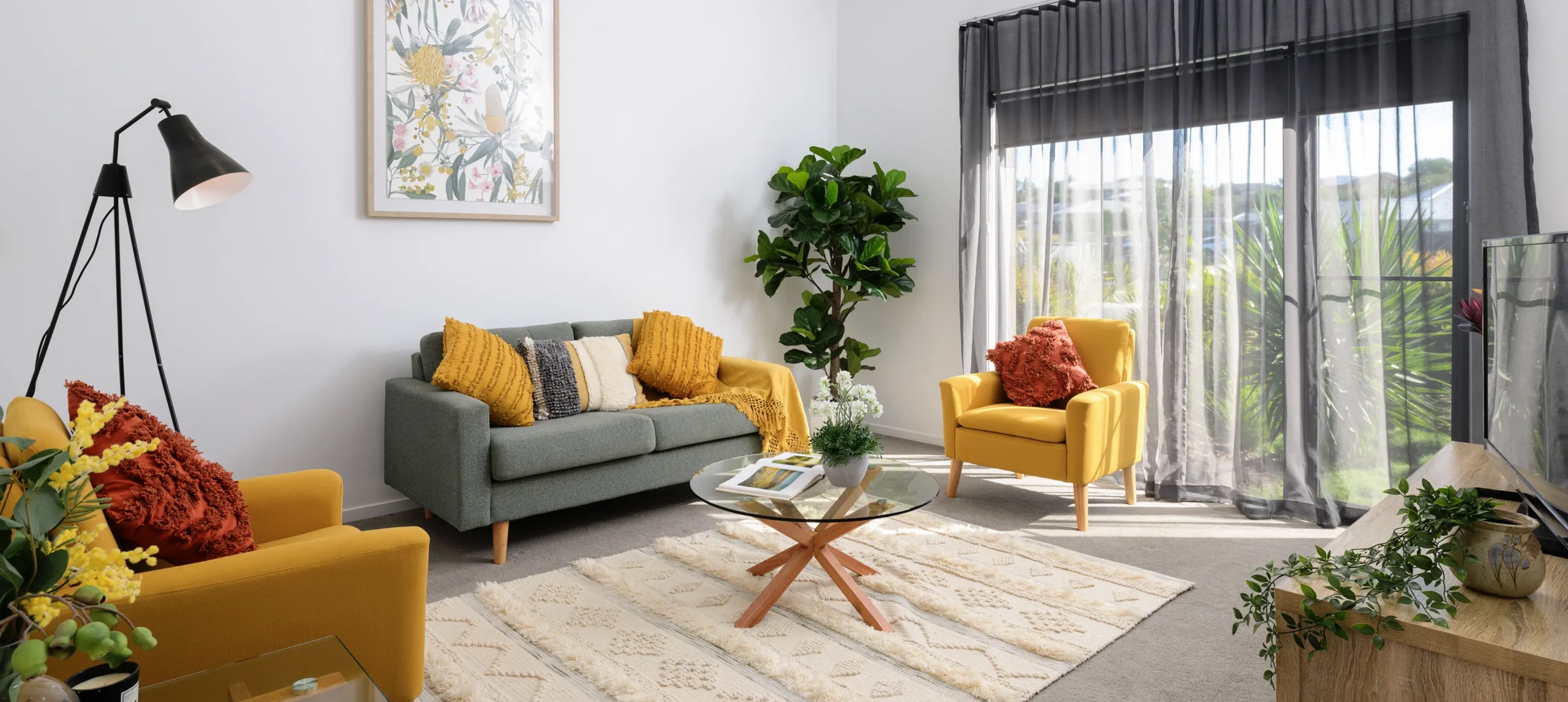 Warm living room styled with mustard accents, sheer curtains and timber coffee table – interior design photography.